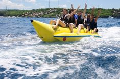 four people are riding on an inflatable boat