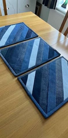 two blue rugs sitting on top of a wooden table