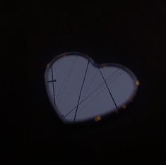 a heart shaped mirror reflecting the sky and power lines in it's center window