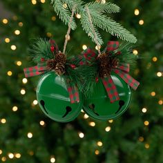 two green christmas bells hanging from a tree