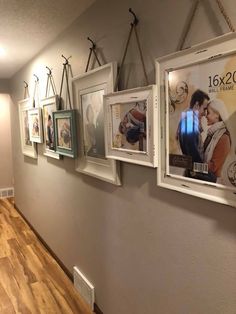 there are pictures hanging on the wall in this hallway, along with other framed photos