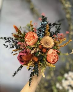 a bouquet of flowers is being held by someone's hand