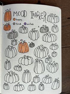 an open notebook with pumpkins drawn on it and the words mood tracker written in black ink