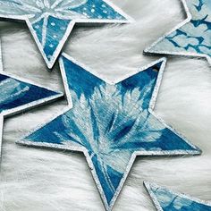 several blue and white stars are shown on a fur surface with snow flakes in the background