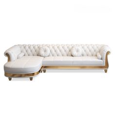 a white couch and ottoman with gold trimmings on the back, in front of a white background