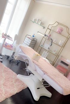 a room that has a pink rug on the floor and some shelves with items in it