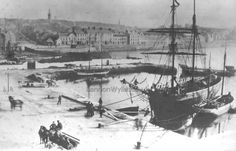 an old black and white photo of boats in the water