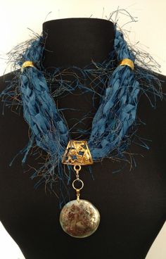 a blue scarf with a medallion hanging from it