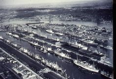 an aerial view of a harbor with many ships in the water and buildings on both sides