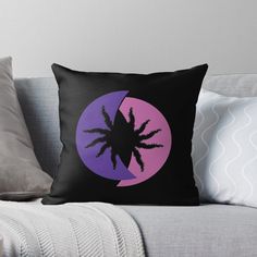 a black and purple throw pillow sitting on top of a couch with the moon in the background