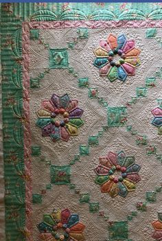 a quilted wall hanging with flowers on it