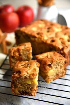 some food that is sitting on a cooling rack next to other foods and fruit in the background