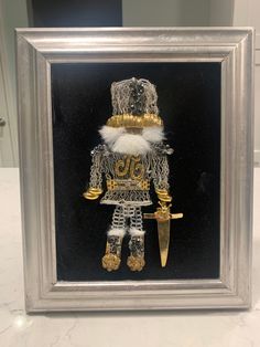 a glass frame with a gold and silver nutcracker in it