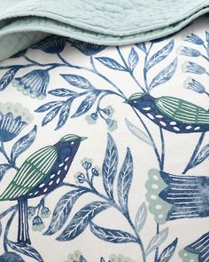 a blue and white pillow with birds on it