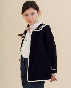 Introducing the Diana Blouse in Off White Plumetis, a timelessly elegant piece perfect for welcoming the season with sophistication. Crafted from delicate cotton for unbeatable comfort, this long-sleeved blouse features a frilled collar and placket, frilled shoulders and delicate mother-of-pearl buttons for a luxurious finish. The Diana Blouse is the perfect addition to your little girl's wardrobe, instantly elevating her look with chic, understated appeal. This blouse combines classic style wit Feminine Doll Collar Workwear Blouse, Classic Fitted Blouse With Peter Pan Collar, Classic White Top With Peter Pan Collar, White Lace Cuff Top With Peter Pan Collar, White Peter Pan Collar Top With Lace Cuffs, Girls Special Occasion Dresses, Baby Boy Shirts, Navy Coat, Sailor Fashion