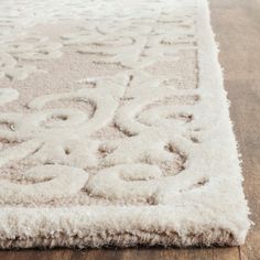 a white rug on top of a wooden floor