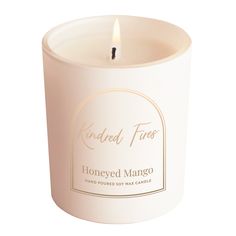 a white candle with a label on it that says honeyed mango in front of a white background