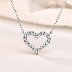 This exquisite piece embodies a perfect blend of elegance and sophistication. Crafted with utmost precision, the heart-shaped pendant is made from sterling silver, radiating a timeless charm. The round cut stones glisten with a captivating brilliance, adding a touch of enchantment to your every ensemble. Wear this mesmerizing necklace as a symbol of love and purity, embracing its graceful beauty close to your heart.Weight: 2.2 gWidth: 15 mmHeight: 13 mmMaterial: 925 SilverPlating Color: SilverLe Valentine's Day Heart Cut Crystal Jewelry, Crystal Clavicle Chain Jewelry For Valentine's Day, Dazzling Heart-shaped Jewelry For Weddings, Crystal Jewelry Valentine's Day Gift For Her, Crystal Jewelry For Valentine's Day Gift, Crystal Jewelry For Valentine's Day Gift For Her, Valentine's Day Crystal Clavicle Chain Jewelry, Valentine's Day Crystal Jewelry Gift For Her, Dazzling Heart Shaped Cubic Zirconia Jewelry