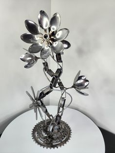 a metal flower sculpture sitting on top of a white table