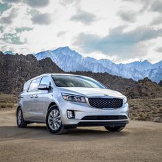 a silver car parked in front of mountains