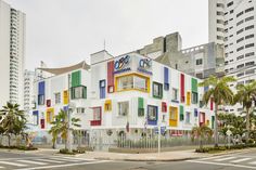 a multi - colored building with palm trees and buildings in the background