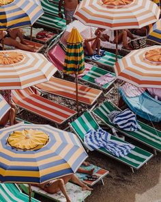 people sitting under umbrellas on the beach