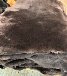 a brown and black dog laying on top of a wooden floor next to a pile of blankets