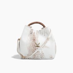 Step into sophistication with our White Leather Handbag featuring a unique round handle, a perfect accessory for those who appreciate elegance with a modern twist. This handbag is meticulously crafted from embossed genuine leather, offering a luxurious texture and feel. The pristine white color, paired with gold metallic details, creates a stunning contrast that enhances any outfit, making it a versatile addition to your wardrobe. Designed with both style and functionality in mind, the handbag f Luxury Handheld Bucket Bag For On-the-go, Luxury Hobo Bag With Adjustable Handle For Travel, Luxury Travel Hobo Bag With Adjustable Handle, Luxury Bags With Double Adjustable Handle, Luxury Bags With Adjustable Handle, Luxury Bucket Bag With Handle Drop, Luxury Bucket Satchel With Detachable Handle, Elegant Formal Bucket Bag With Adjustable Handle, Luxury Bucket Bag With Top Carry Handle