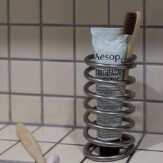 a toothbrush and tube sitting on top of a tile floor next to a tiled wall