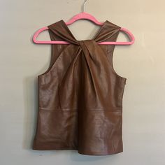 From Antonio Melani, This Top Features: Halter Neckline With Twist Detail Sleeveless Side Zip Closure Approx. 22.75" Length Genuine Leather; Lining: Polyester Leather Method Dry Cleaning Imported. Color Is Chestnut Approx: Pit To Pit 33”( Size Xs) Length 22” Pit To Pit 43” Length 26” Last Photo Taken Near A Window. True Color. Models Are Wearing It In Different Colors. Elegant Sleeveless Blouse Tank Top For Fall, Chic Fitted Leather Vest, Sleeveless Leather Work Vest, Spring Leather Sleeveless Vest, Sleeveless Leather Vest For Spring, Leather Sleeveless Vest For Spring, Chic Leather Tops For Summer, Elegant Sleeveless Brown Tops, Chic Brown Tank Vest