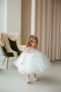 Looking for the perfect dress for your little one's special occasion? Look no further than this beautiful white flower girl dress! Crafted with exquisite attention to detail, this dress is sure to make your little girl feel like a princess on her big day. The delicate tulle tutu and intricate floral detailing are perfect for a first birthday, baptism, first communion, or pageant event. The dress is made from high-quality materials that are gentle on your baby's delicate skin. The soft tulle skir White Princess Baptism Dress With Tulle Skirt, White Tulle First Communion Dress With Ruffles, White Tulle First Communion Dress With Tulle Skirt, Elegant White Dress For First Birthday, White Princess Dress For First Birthday, White Baptism Dress With Tulle Skirt, White Tulle Pageant Dress For First Communion, Elegant White Tulle Pageant Dress, Elegant White Pageant Dress With Tulle Skirt