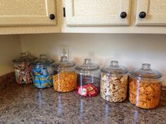 several jars filled with food sitting on top of a kitchen counter