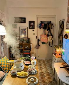 a living room filled with furniture and a flat screen tv sitting on top of a wooden table