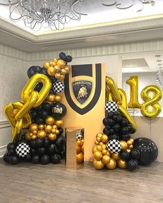 a large number balloon display with black and gold balloons