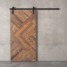 a wooden door hanging on a wall next to a metal bar with a black handle