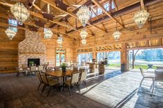 a large dining room with wood paneling and chandeliers