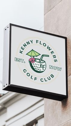 a sign hanging off the side of a building advertising a golf club with a green umbrella