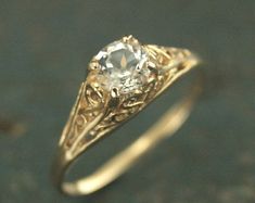 an antique diamond ring with filigrees on the sides, set in yellow gold