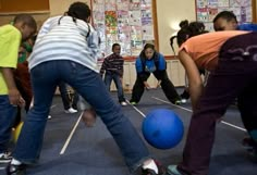 a group of people playing with a ball in a room