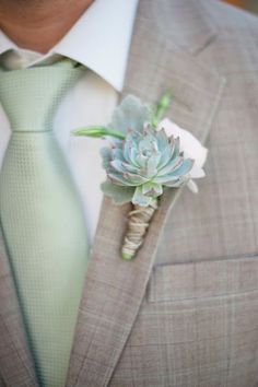 a man wearing a suit and tie with a boutonniere on his lapel