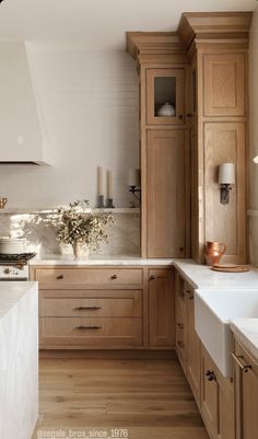 a kitchen filled with lots of wooden cabinets and white counter tops next to a stove top oven