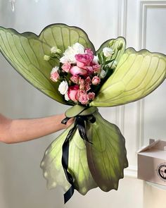 a person holding a bouquet of flowers in their hand