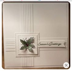 a christmas card with holly leaves on it and the words season's greetings