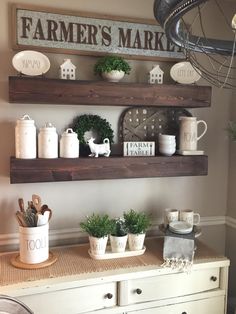 two wooden shelves with plants and other items on top of them in front of a white dresser