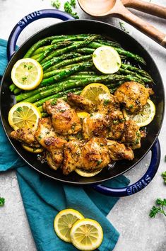 chicken and asparagus in a pan with lemons