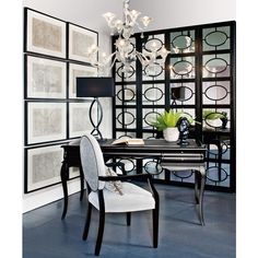 a black and white dining room with chandelier, chair, table and pictures on the wall