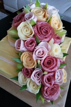 a bouquet of flowers is sitting on top of a cake that looks like it has been made out of paper