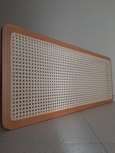 a large wooden speaker sitting on top of a white tile floor next to a wall