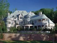 a large white house sitting on top of a lush green field