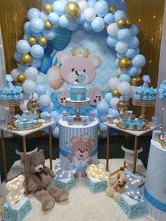 a teddy bear themed birthday party with blue and gold decorations, balloons, and cake